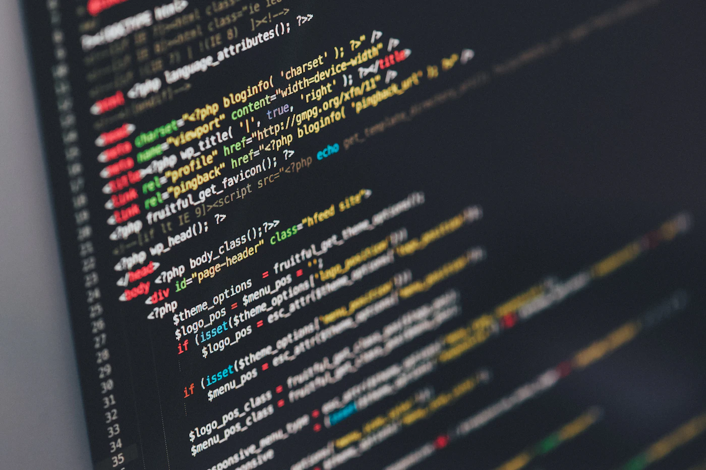 Close-up of colourful source code on a dark editor screen, representing software and web development