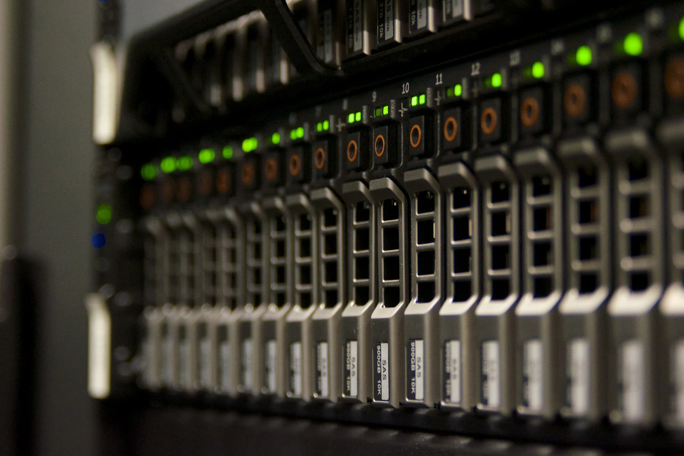 Close-up of rows of server units with glowing green status lights in a data centre