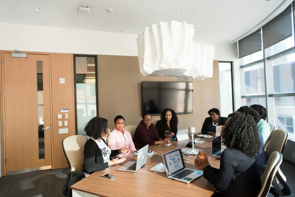 A team working together around a meeting table with laptops in a bright office